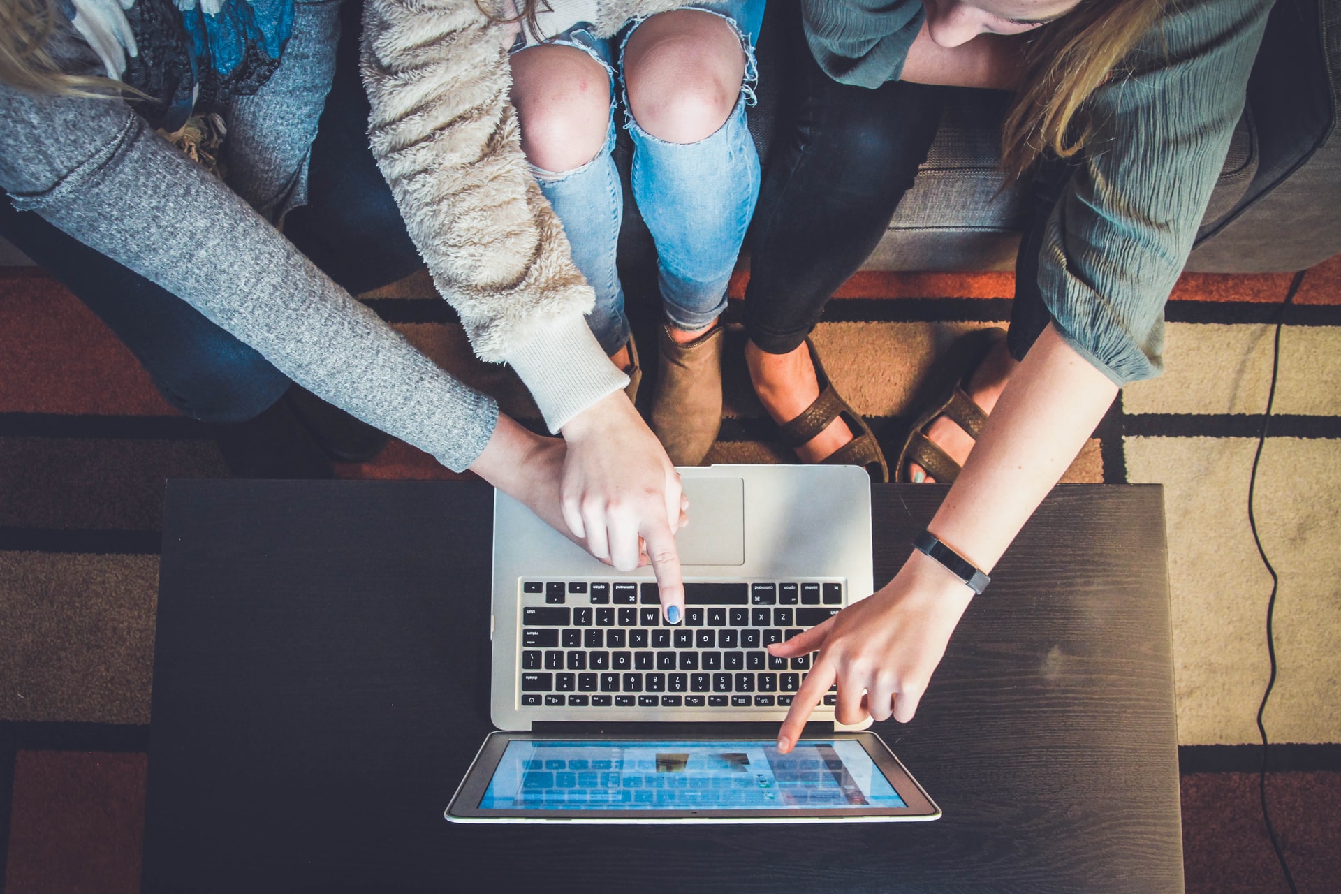 Three people working together at one laptop